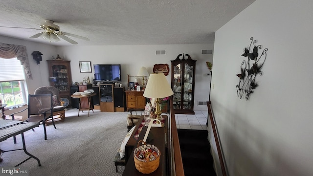 interior space featuring a textured ceiling, ceiling fan, and carpet floors