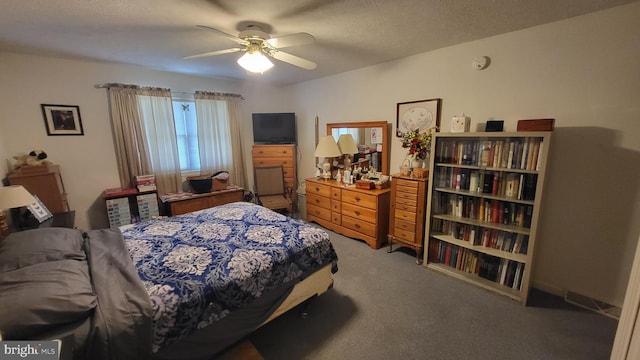 carpeted bedroom with ceiling fan and a textured ceiling