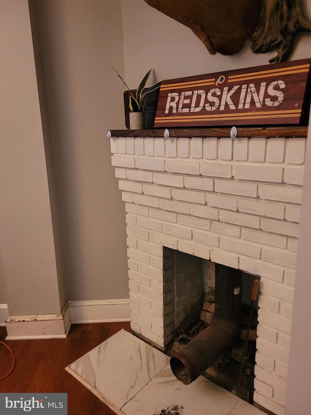 details featuring a brick fireplace and hardwood / wood-style flooring