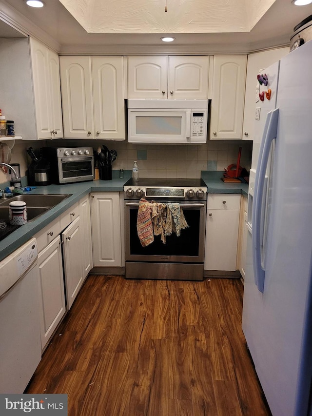 kitchen featuring white cabinets, white appliances, and dark wood-type flooring