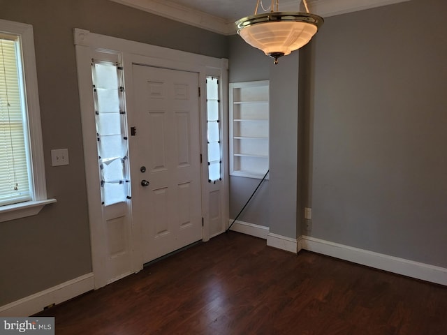 foyer with ornamental molding and dark wood-type flooring