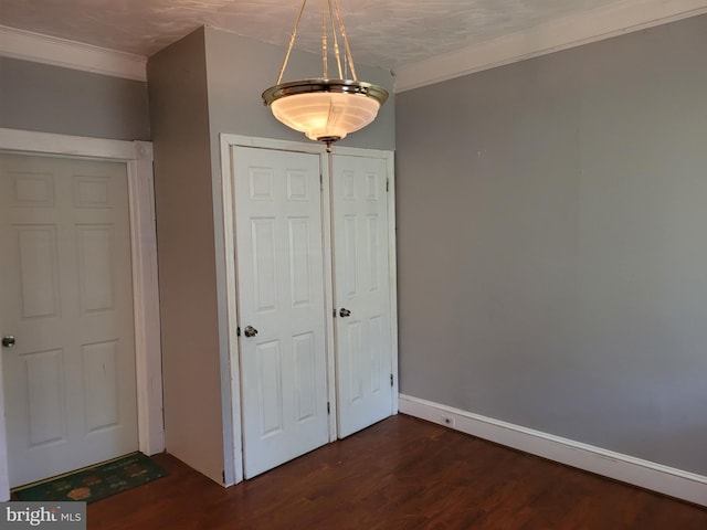 unfurnished bedroom with ornamental molding and dark wood-type flooring