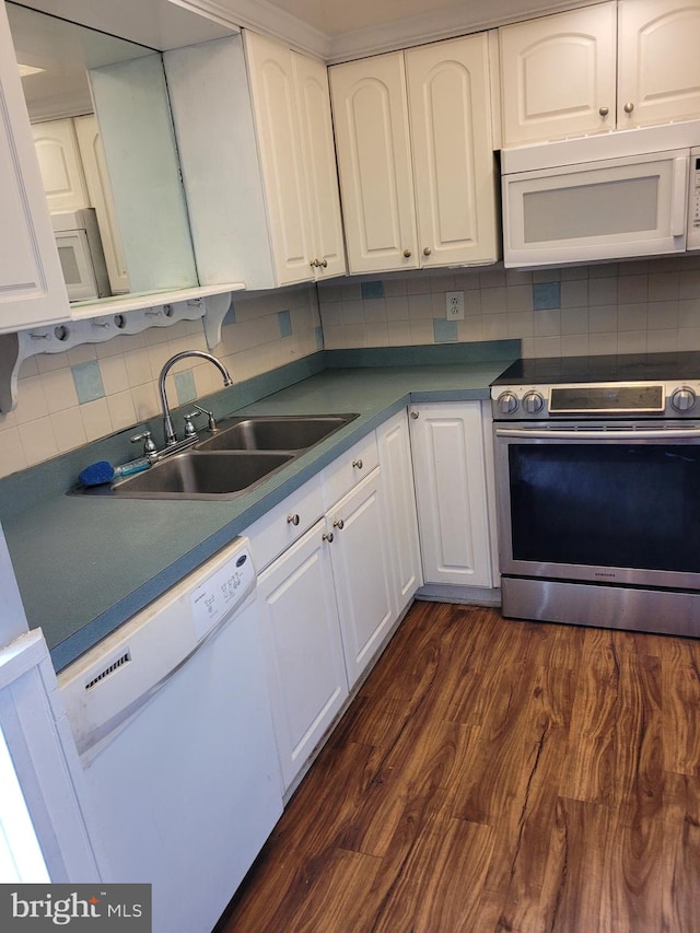 kitchen with white appliances, white cabinetry, sink, and dark wood-type flooring