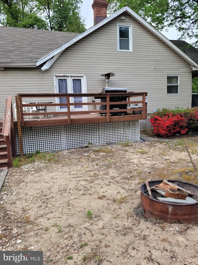 rear view of property featuring a deck and an outdoor fire pit