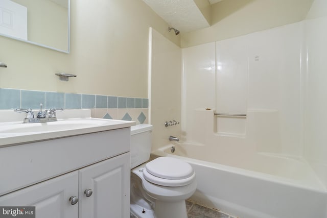 full bathroom featuring vanity, tub / shower combination, toilet, and tile walls