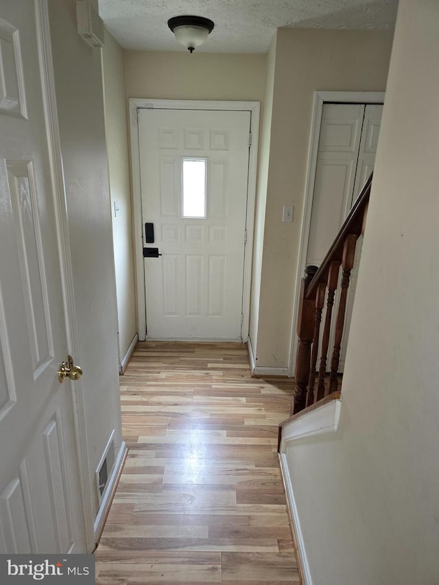 entryway featuring a textured ceiling and light wood-type flooring