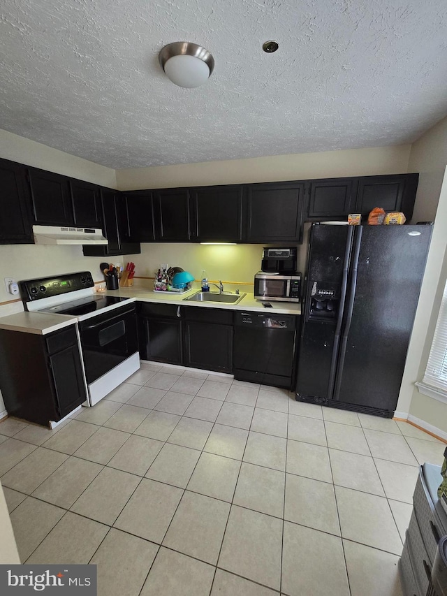 kitchen with light tile patterned floors, sink, a textured ceiling, and black appliances