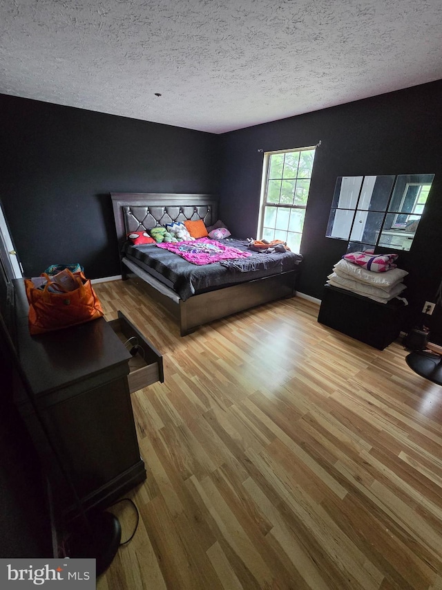 bedroom featuring a textured ceiling and light wood-type flooring