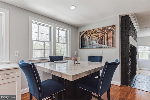 dining area featuring a healthy amount of sunlight and dark hardwood / wood-style flooring