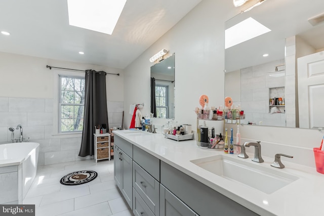 bathroom with a bath to relax in, tile flooring, tile walls, and double sink vanity