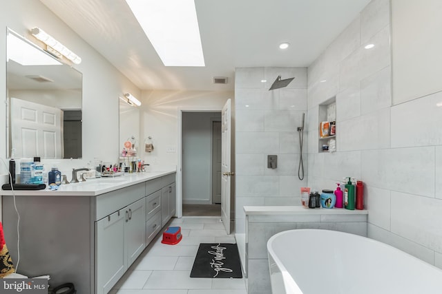 bathroom with oversized vanity, tile walls, a tub, and tile floors