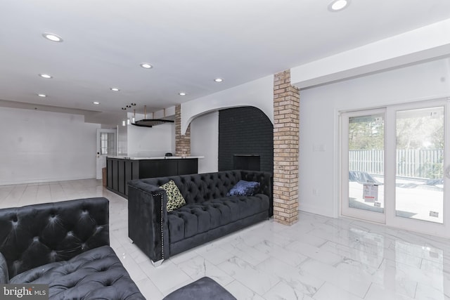 living room with brick wall, light tile flooring, and a brick fireplace