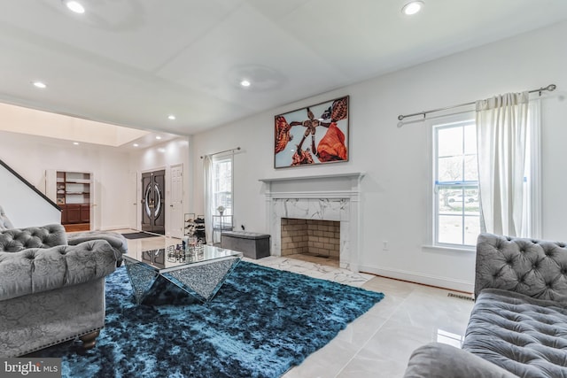 living room featuring a fireplace, a wealth of natural light, and light tile floors