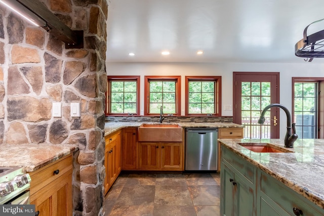 kitchen with light stone countertops, sink, and appliances with stainless steel finishes