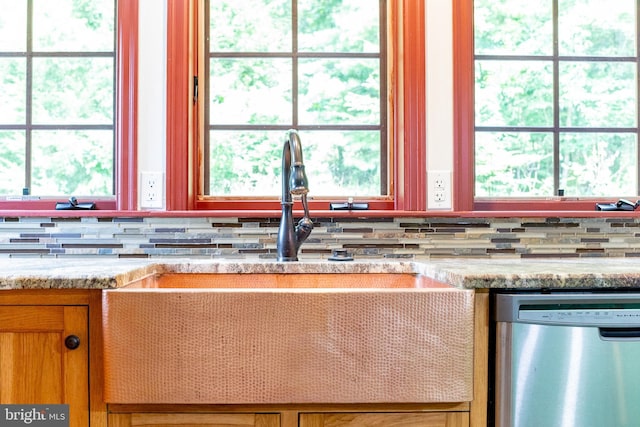 kitchen with light stone countertops and dishwasher