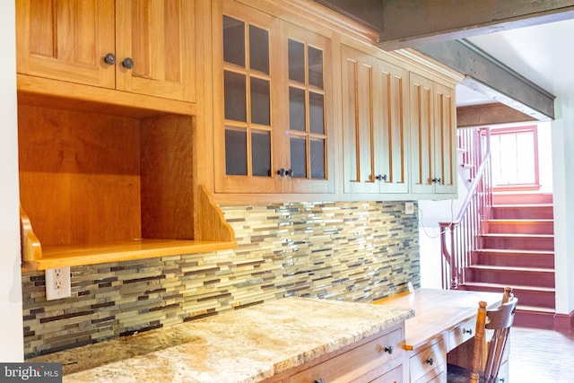 kitchen with tasteful backsplash, beamed ceiling, and light stone counters