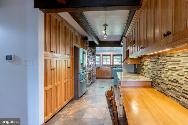 kitchen featuring sink, tasteful backsplash, and stainless steel fridge