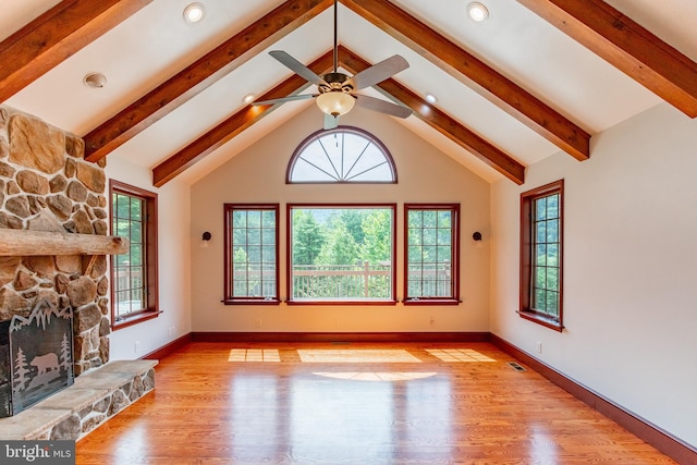 unfurnished living room with ceiling fan, light hardwood / wood-style floors, plenty of natural light, and a stone fireplace