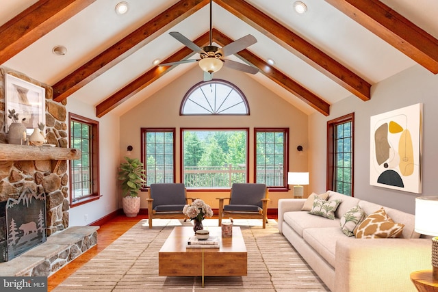 living room featuring ceiling fan, plenty of natural light, light hardwood / wood-style floors, and a fireplace