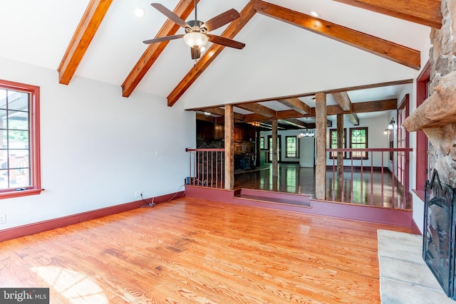 unfurnished living room featuring ceiling fan, a fireplace, high vaulted ceiling, and light wood-type flooring