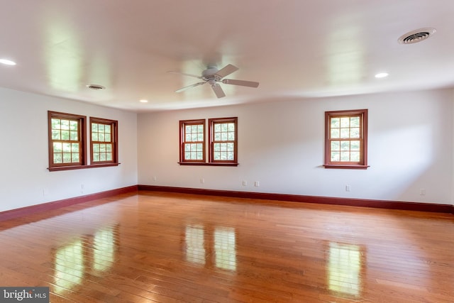 spare room with ceiling fan and light wood-type flooring