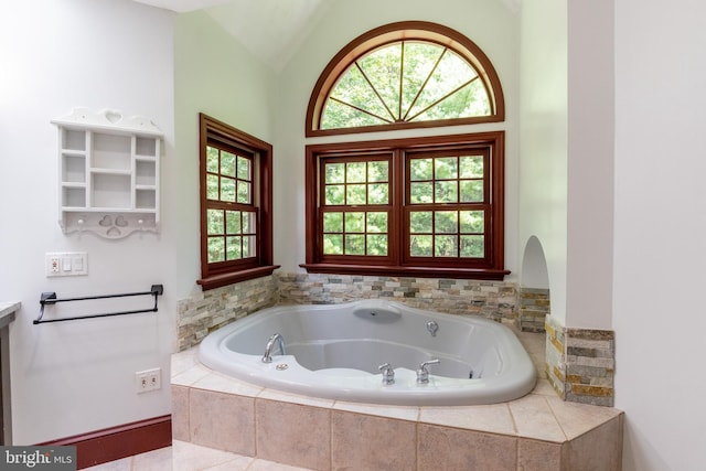 bathroom with a relaxing tiled tub and lofted ceiling