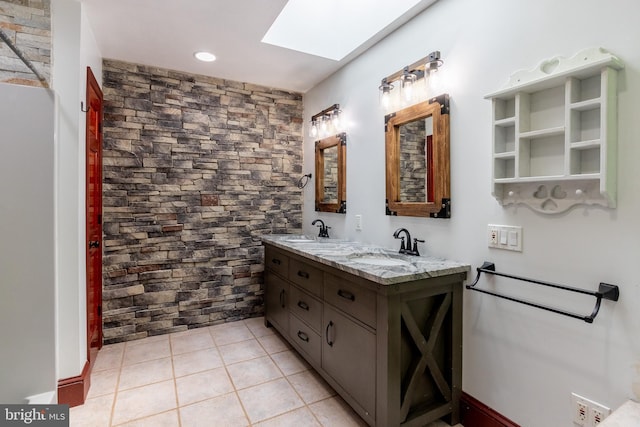 bathroom with tile patterned flooring, vanity, and a skylight