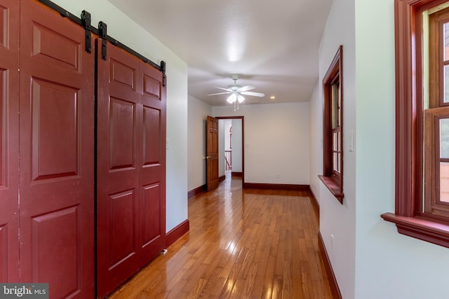 hallway featuring a barn door and light wood-type flooring