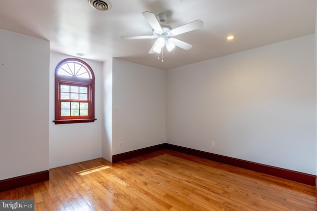 empty room with ceiling fan and light hardwood / wood-style flooring