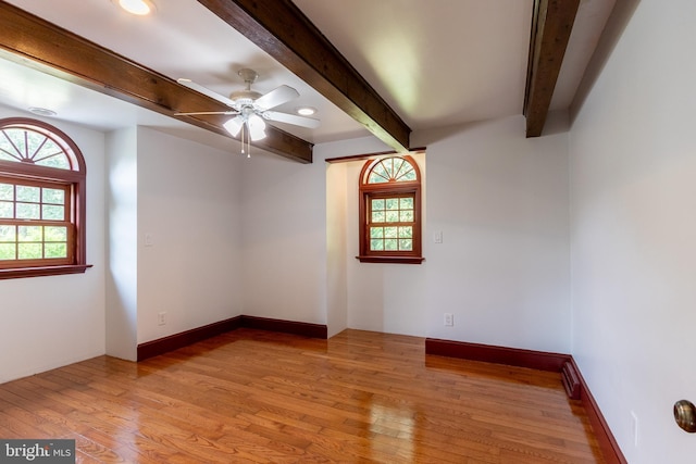 unfurnished room with ceiling fan, light hardwood / wood-style floors, and beam ceiling