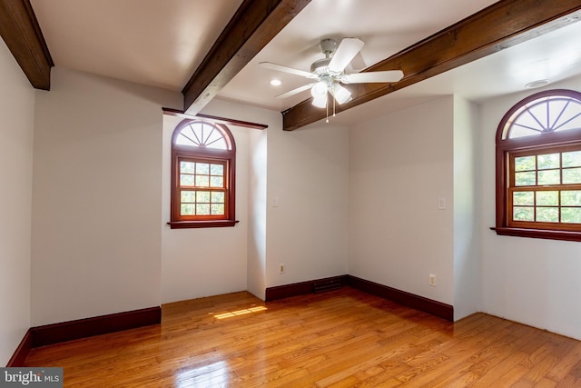 empty room with light wood-type flooring, ceiling fan, and beamed ceiling