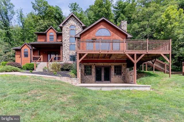 rear view of house featuring a lawn, french doors, and a deck