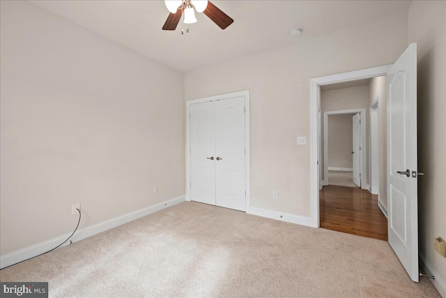 unfurnished bedroom with a closet, ceiling fan, and light carpet