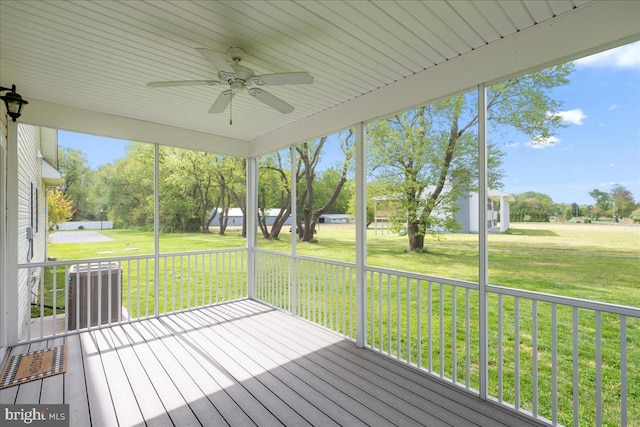 deck featuring ceiling fan, central AC unit, and a lawn