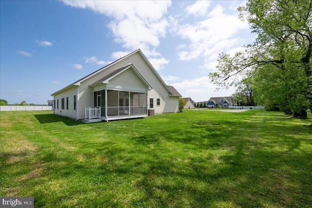 back of property with a sunroom and a yard