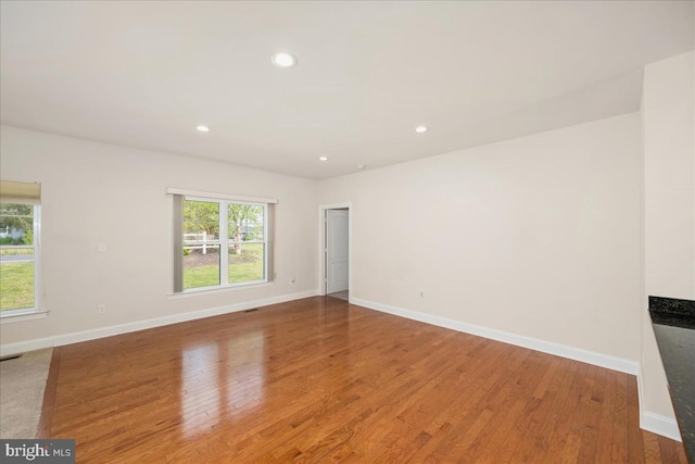 empty room with a wealth of natural light and wood-type flooring