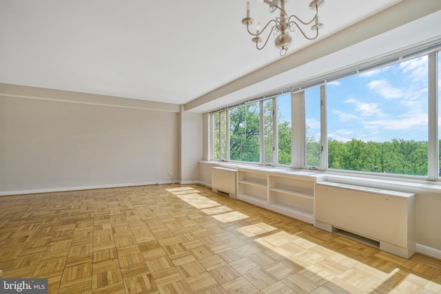 unfurnished sunroom featuring a chandelier and radiator heating unit