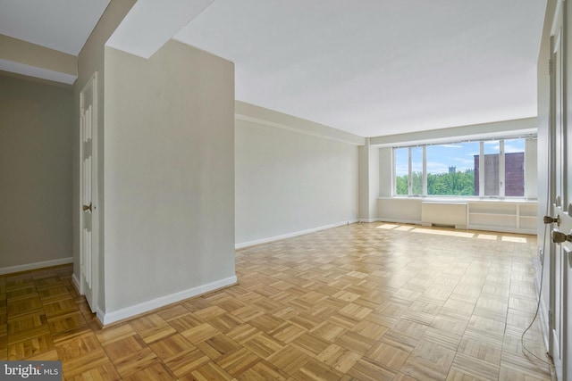 empty room with radiator heating unit and light parquet floors