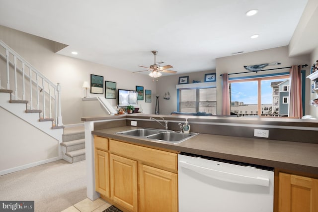 kitchen with light brown cabinets, ceiling fan, dishwasher, light carpet, and sink