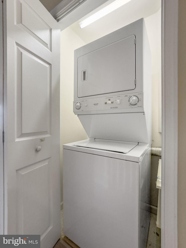 washroom featuring stacked washing maching and dryer