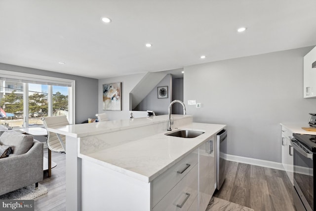 kitchen featuring sink, light hardwood / wood-style floors, white cabinetry, and light stone counters