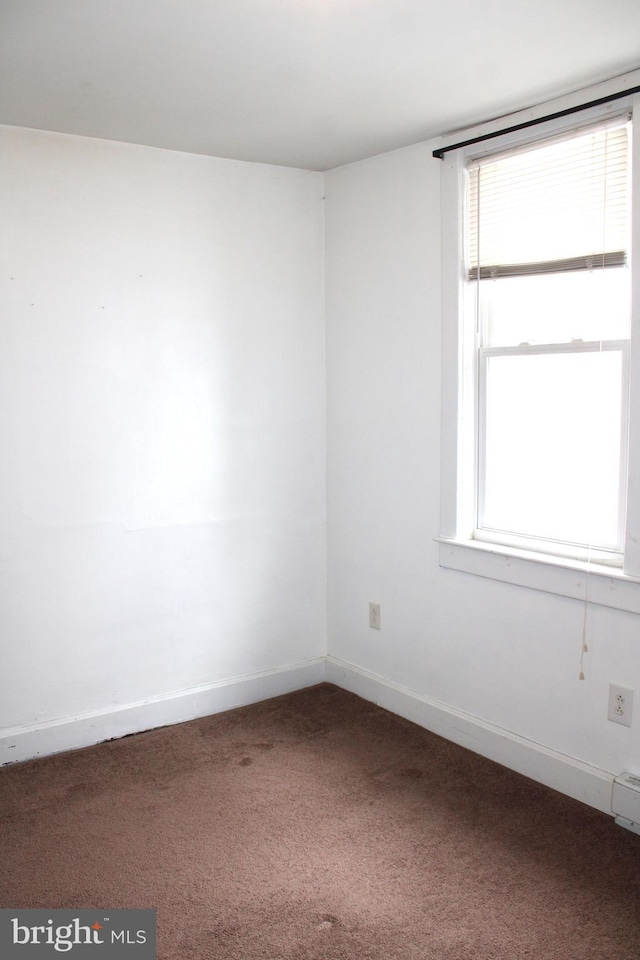 carpeted spare room featuring a healthy amount of sunlight