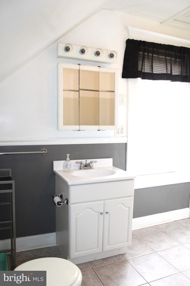 bathroom featuring vanity, toilet, tile patterned flooring, and vaulted ceiling