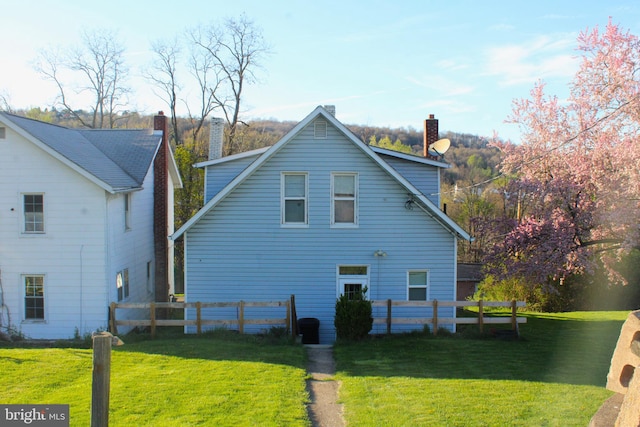 back of property featuring a lawn