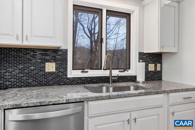 kitchen with light stone counters, sink, tasteful backsplash, white cabinetry, and stainless steel dishwasher