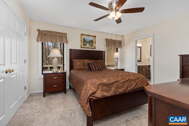 carpeted bedroom with ceiling fan and ensuite bath