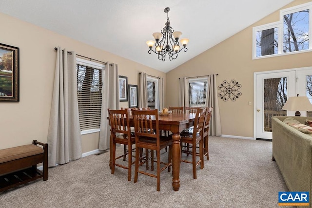 carpeted dining room with an inviting chandelier and high vaulted ceiling