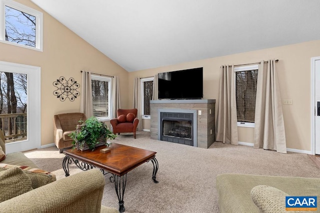 carpeted living room with high vaulted ceiling and a tiled fireplace