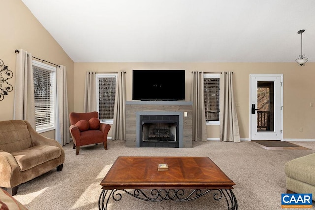 living room with light colored carpet, a tile fireplace, and vaulted ceiling