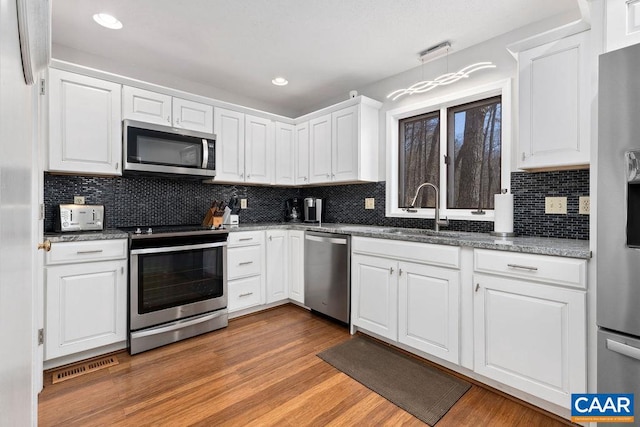 kitchen featuring sink, light hardwood / wood-style floors, white cabinetry, and stainless steel appliances